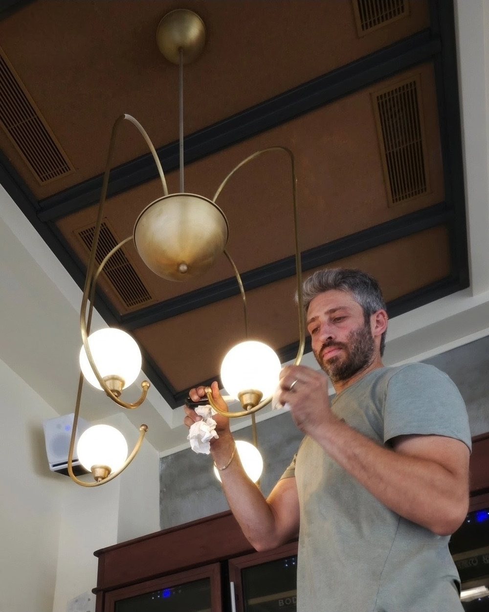 עידן הרבט מתקין את גוף התאורה במסעדת ויוי