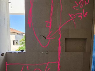 חדר רחצה בשיפוץ, עם סימונים על הקיר