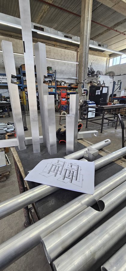 פרופילי אלומיניום חתוכים והשרטוט של HBS 01 על שולחן העבודה