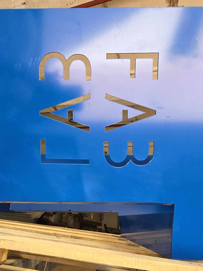 עמוד הלוגו הכחול על משטח, עם האותיות החתוכות