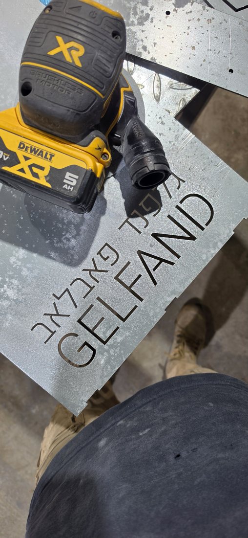 מלטשת על הפח סביב האותיות GELFAND, לפני הצבע